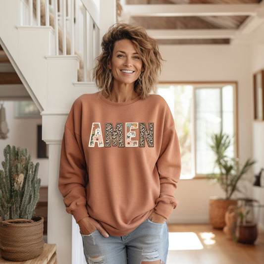 Amen sweatshirt in a beautiful burnt orange color. Faux embroidery printed on it with the words amen. letters are a floral and leopard design in fall colors.