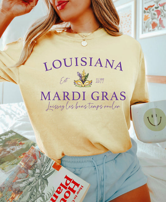 light yellow comfort colors cotton tee with the words louisiana mardi gras with a mardi gras mask in the middle